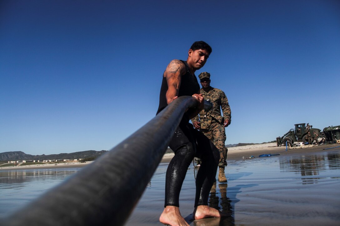 U.S. Marine Lance Cpl. Fransisco  Hernandez, front, drags a water purification pipe from the surf aboard Camp Pendleton, Calif., March 6, 2015. Hernandez is a water purification specialist with Combat Logistics Battalion 15, 15th Marine Expeditionary Unit. The Marines made drinking water by running ocean water through a tactical water purification system during Amphibious Squadron/Expeditionary Unit Integration Training (PMINT).   (U.S. Marine Corps photo by Cpl. Elize McKelvey/Released)