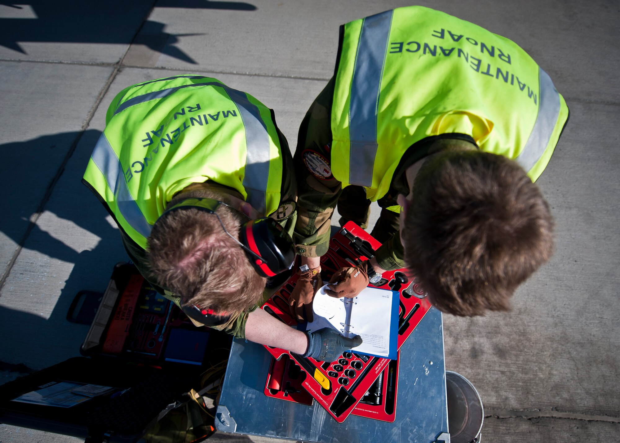 Royal Norwegian Air Force 2nd Lts. Knut Arnevik and Erlemd Aannoe, both 338th Squadron maintainers, look over a technical order during Red Flag 15-2 at Nellis Air Force Base, Nev., March 6, 2015. Red Flag is a realistic combat exercise involving U.S. and allied air forces conducting training operations on the 15,000 square mile Nevada Test and Training Range during day and night operations. (U.S. Air Force photo by Staff Sgt. Siuta B. Ika)