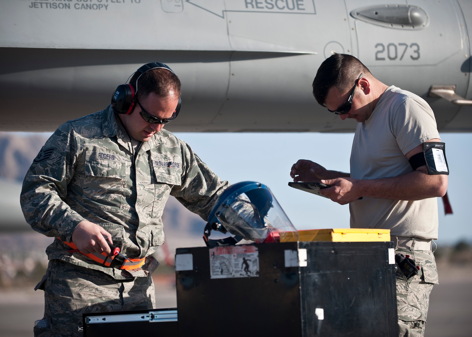 Staff Sgt. Derek Rogers and Airman 1st Class Matt Stevens, both crew chiefs assigned to the 125th Aircraft Maintenance Squadron, Tulsa Air National Guard Base, Okla., prepare to work on an F-16 Fighting Falcon during Red Flag 15-2 at Nellis Air Force Base, Nev., March 6, 2015. Crew chiefs are responsible for and dedicated to a single aircraft, and have their name stenciled on the aircraft along with the pilot’s. (U.S. Air Force photo by Staff Sgt. Siuta B. Ika)