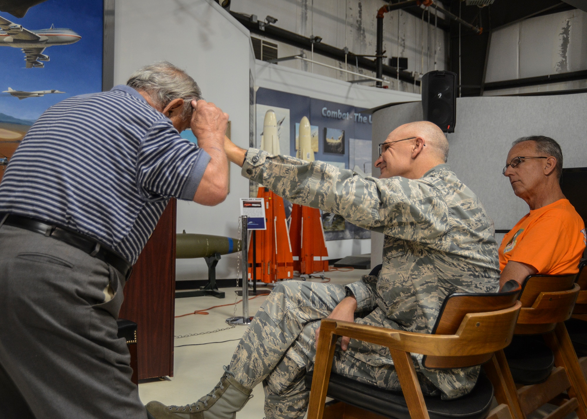 Albert Rosa shows Maj. Gen. Arnold Bunch, Air Force Test Center commander, the injury he sustained to his head in Nazi Germany. Rosa sustained many other injuries including a broken arm, a bullet wound in his knee and a bayonet wound in his stomach. (U.S. Air Force photo by Rebecca Amber)