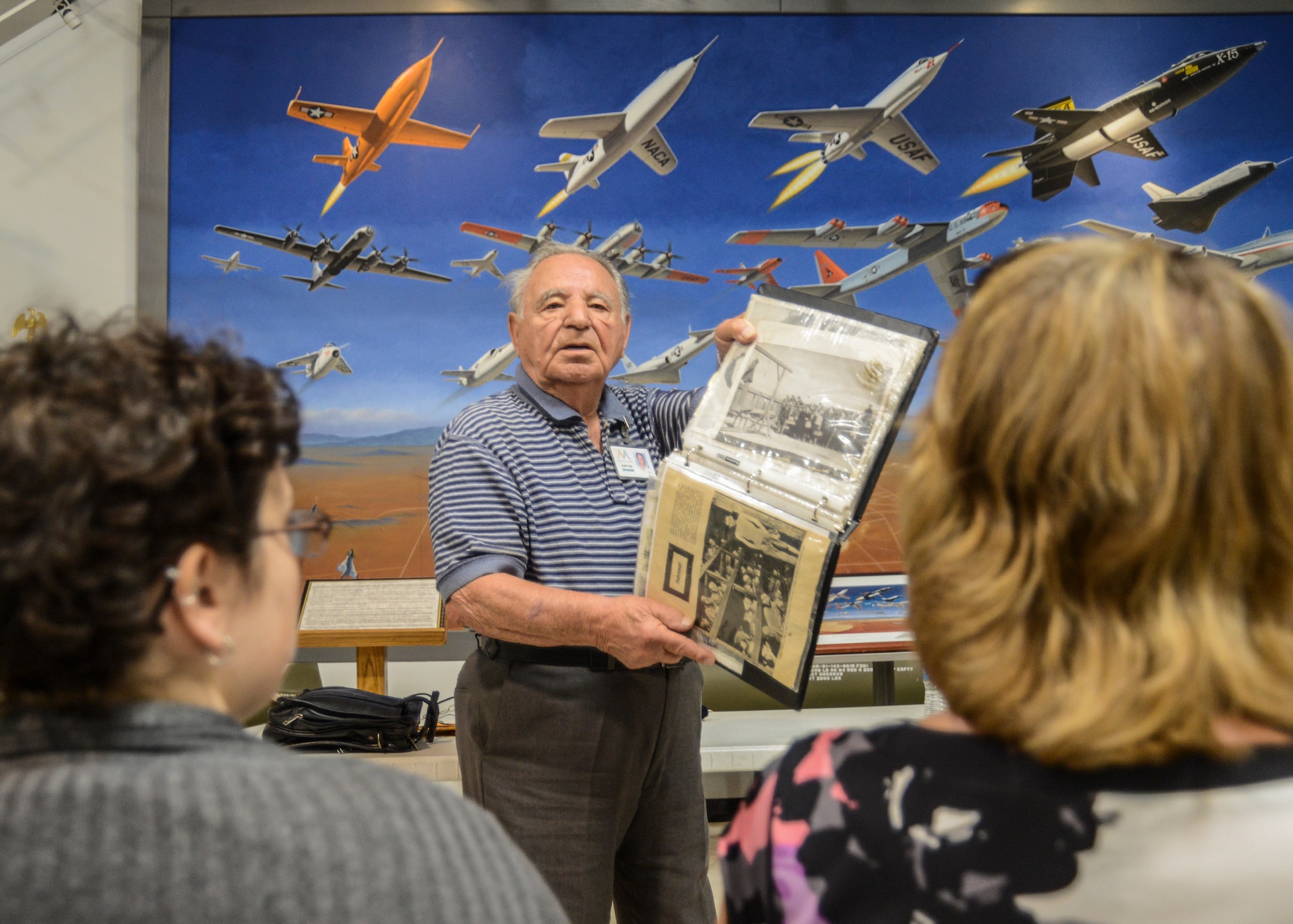 Albert Rosa shares newspaper clippings that show the living quarters inside of a concentration camp during World War II. The people held there were frail from starvation and forced to sleep with 8 to 10 people put in each bed. (U.S. Air Force photo by Rebecca Amber)