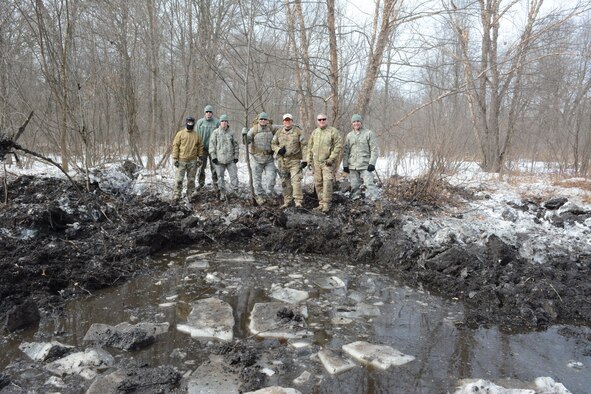 The 115th Fighter Wing Explosive Ordnance Disposal team pauses for a photo following their successful explosive training exercise in Finley, Wis., March 6, 2015. The EOD team used their knowledge to clear a waterway and prevent future flooding for the Juneau County Forestry Department. Once the ice melts, this area will have free-flowing water running through it. (U.S. Air National Guard photo by Senior Airman Andrea F. Rhode)