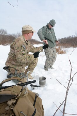 Tech. Sgt. Erich Sanford and Senior Airman Joshua Wilcox, 115th Fighter Wing Explosive Ordnance Disposal, prepare the detonation cord prior to an explosive training exercise in Finley, Wis., March 6, 2015. The EOD team used their training exercise to clear a waterway for the Juneau County Forestry Department, preventing possible floods in the local area. (U.S. Air National Guard photo by Senior Airman Andrea F. Rhode)