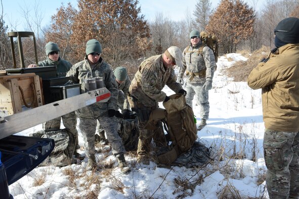 Explosive Ordnance Disposal Airmen from the 115th Fighter Wing load their rucksack with explosives during a training exercise in Finley, Wis., March 6, 2015. The EOD team used their training exercise to clear a waterway for the Juneau County Forestry Department using their explosive knowledge. The exercise gave the young Airmen a chance to see the benefits of their training live. (U.S. Air National Guard photo by Senior Airman Andrea F. Rhode)