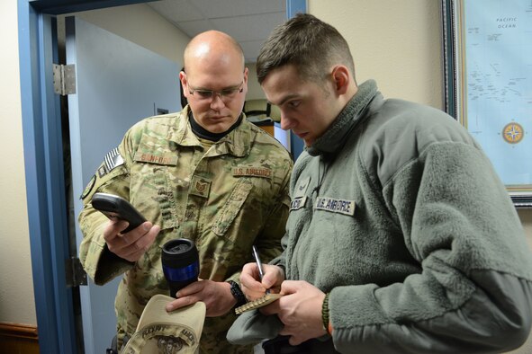 Tech. Sgt. Erich Sanford and Senior Airman Joshua Wilcox, 115th Fighter Wing Explosive Ordnance Disposal, review location coordinates prior to their training exercise in Finley, Wis., March 6, 2015. The EOD team was able to use their training exercise to clear a waterway of debris for the Juneau County Forestry Department. (U.S. Air National Guard photo by Senior Airman Andrea F. Rhode)