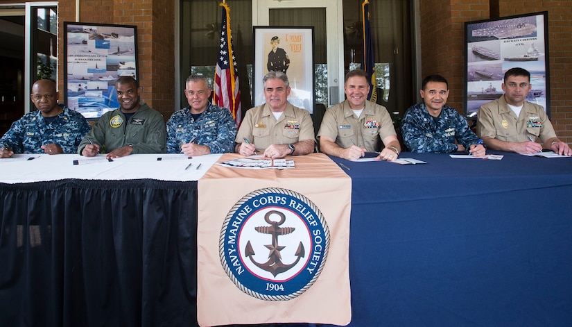 From left to right, Lieutenant Commander Samuel Crum, Naval Health Clinic Charleston Comptroller; Cmdr. Steven Jones, Navy Operational Support Center Charleston commanding officer; Capt. Charles Phillip, Naval Munitions Command Unit Charleston commanding officer; Capt. Timothy Sparks, Joint Base Charleston deputy commander; Capt. John Fahs, Naval Nuclear Power Training Command commanding officer; Cmdr. Baldomero Garcia, SPAWAR Systems Center Atlantic Engineering Military deputy; and GSCS William Schmelling, Naval Consolidated Brig Charleston Prisoner Management, sign the Navy Marine Corps Relief Society Fund Drive March 5, 2015, at Storme Point on Joint Base Charleston - Weapons Station. All donations made to the NMCRS are used to assist any Sailors or Marines with personal financial emergencies. The drive is held through March 31, 2015. To donate call (843) 794-8218 or send an email to adrian.jones.10@us.af.mil (U.S. Air Force photo/ Senior Airman Dennis Sloan)