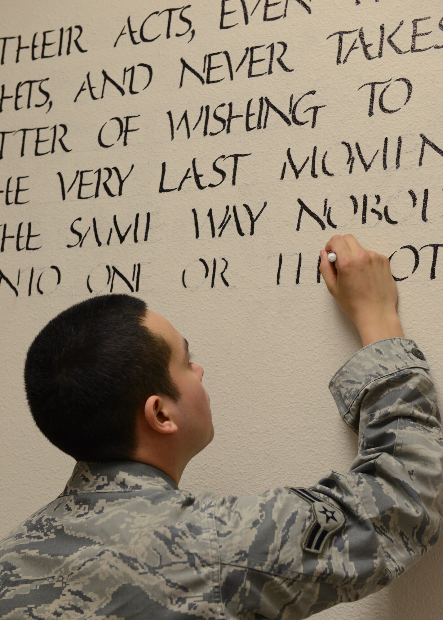 U.S. Air Force Airman 1st Class Danny Banderas, 354th Security Forces Squadron response force leader, fills in words to an inspirational quote seen on the walls of the security forces building Feb. 26, 2015, Eielson Air Force Base, Alaska. Banderas is one of two defenders who have painted the security forces building interior with a thin blue line and posted various inspirational quotes as reminders of what it means to wear the badge every day. (U.S. Air Force photo by Senior Airman Ashley Nicole Taylor/Released)