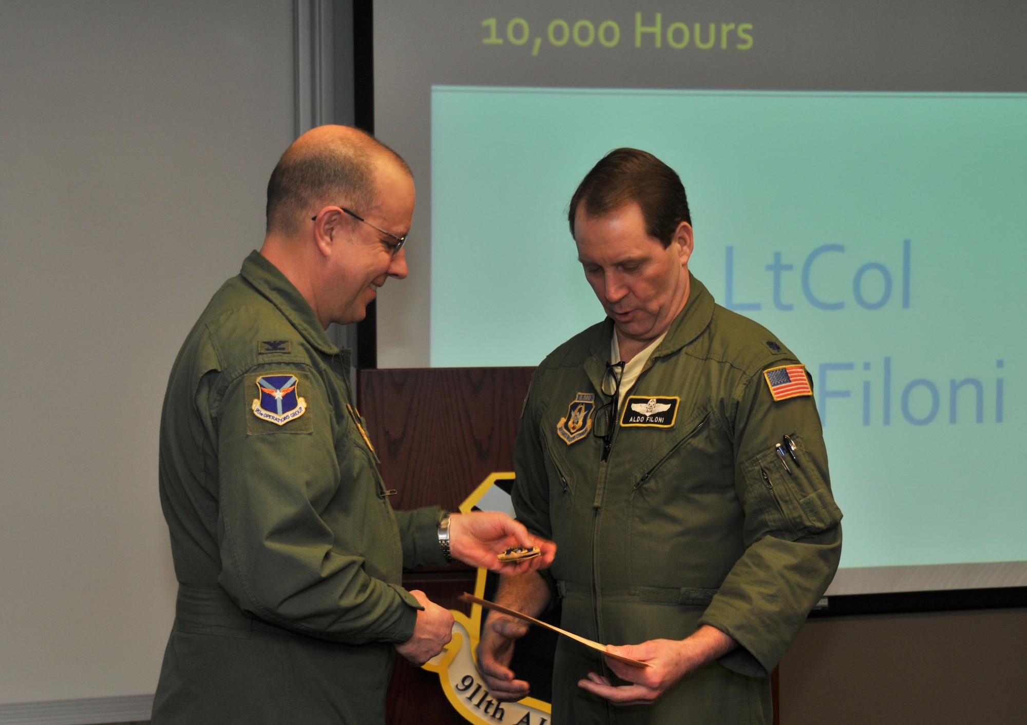 Lt. Col. Aldo Filoni, primary evaluator navigator with the 911th Operations Group, receives the Individual Mishap Free Flying Hour Award from 911th OG Commander Col. Joseph Potts during a group safety briefing here, March 8, 2015. Filoni flew 10,000 hours without a serious mishap and was recognized by wing safety for his achievements. (U.S. Air Force photo by Senior Airman Marjorie A. Bowlden)