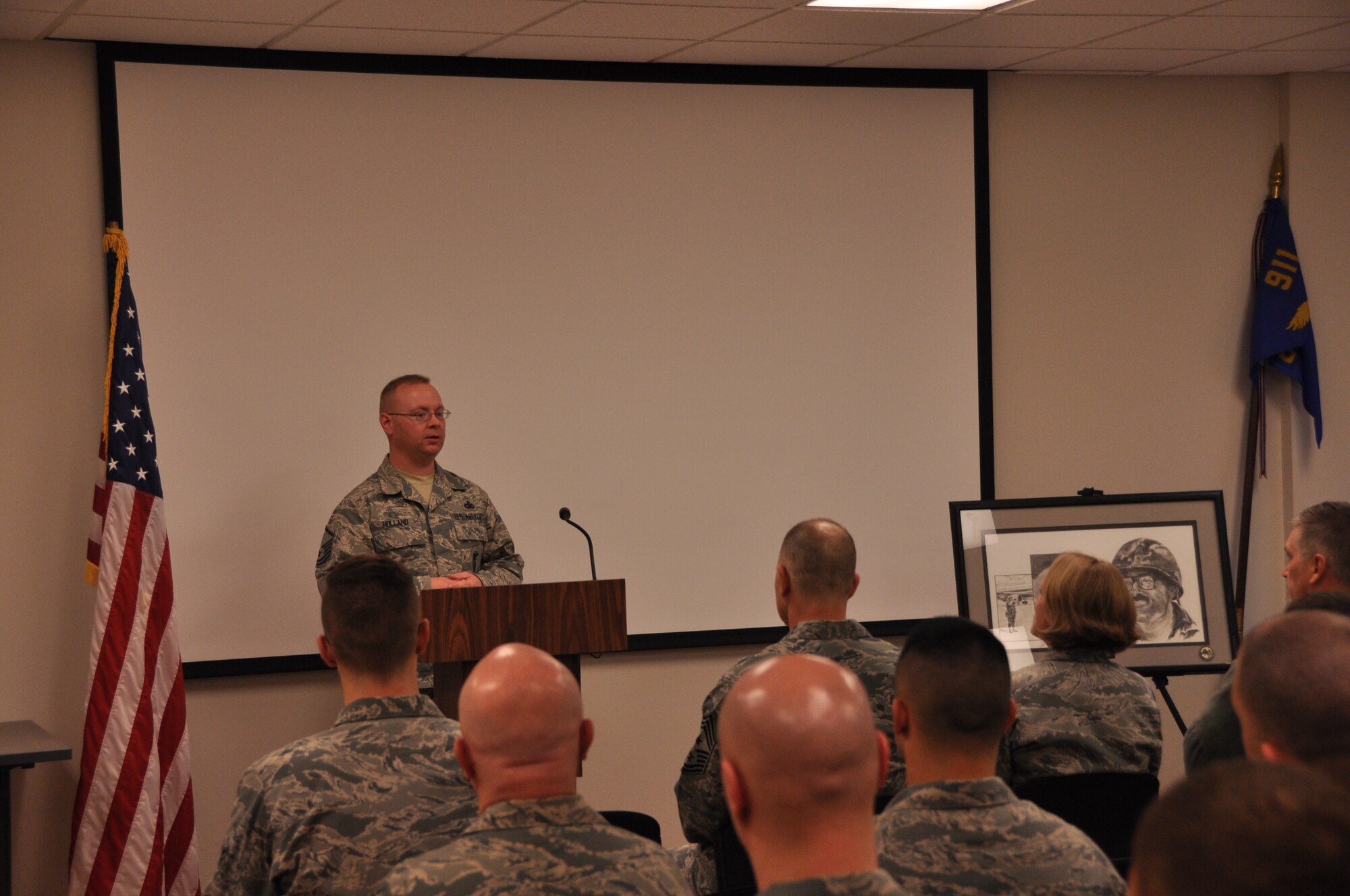 Master Sgt. Robert T. Holland, son of retired Chief Master Sgt. Robert D. Holland, speaks during a re-dedication ceremony inside Holland Hall, named in honor of his late father, March, 08, 2015. Holland Hall has recently undergone a seven-month  renovation to ensure that security forces members have the adequate facilities needed to complete the Air Force Reserve mission. There was also a new award established and named in honor of Chief Holland this year. It will be awarded to the top Active Guard Reserve Security Forces patrolman or civilian officer who best epitomizes the characteristics attributed to Chief Holland. (U.S. Air Force photo by Senior Airman Joseph E. Bridge)