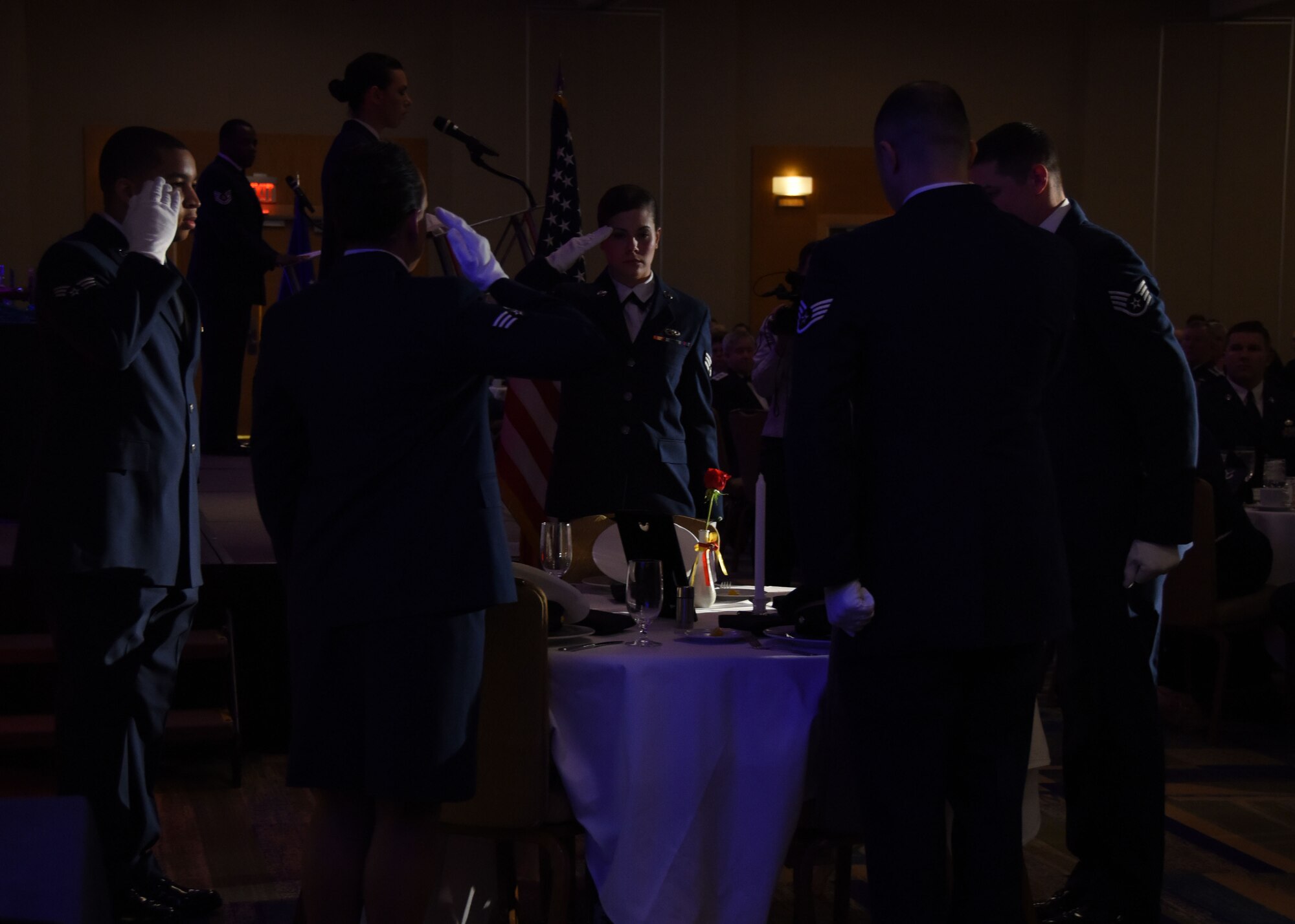 Members of the 911th Airlift Wing MIA POW team salute in remembrance of fallen prisoners of war and those missing in action at the  2015 911th AW annual Awards Banquet, March 7, 2015. A POW table serves as a reminder for the service members who are no longer with us. (U.S. Air Force photo by Staff Sgt. Justyne Obeldobel)