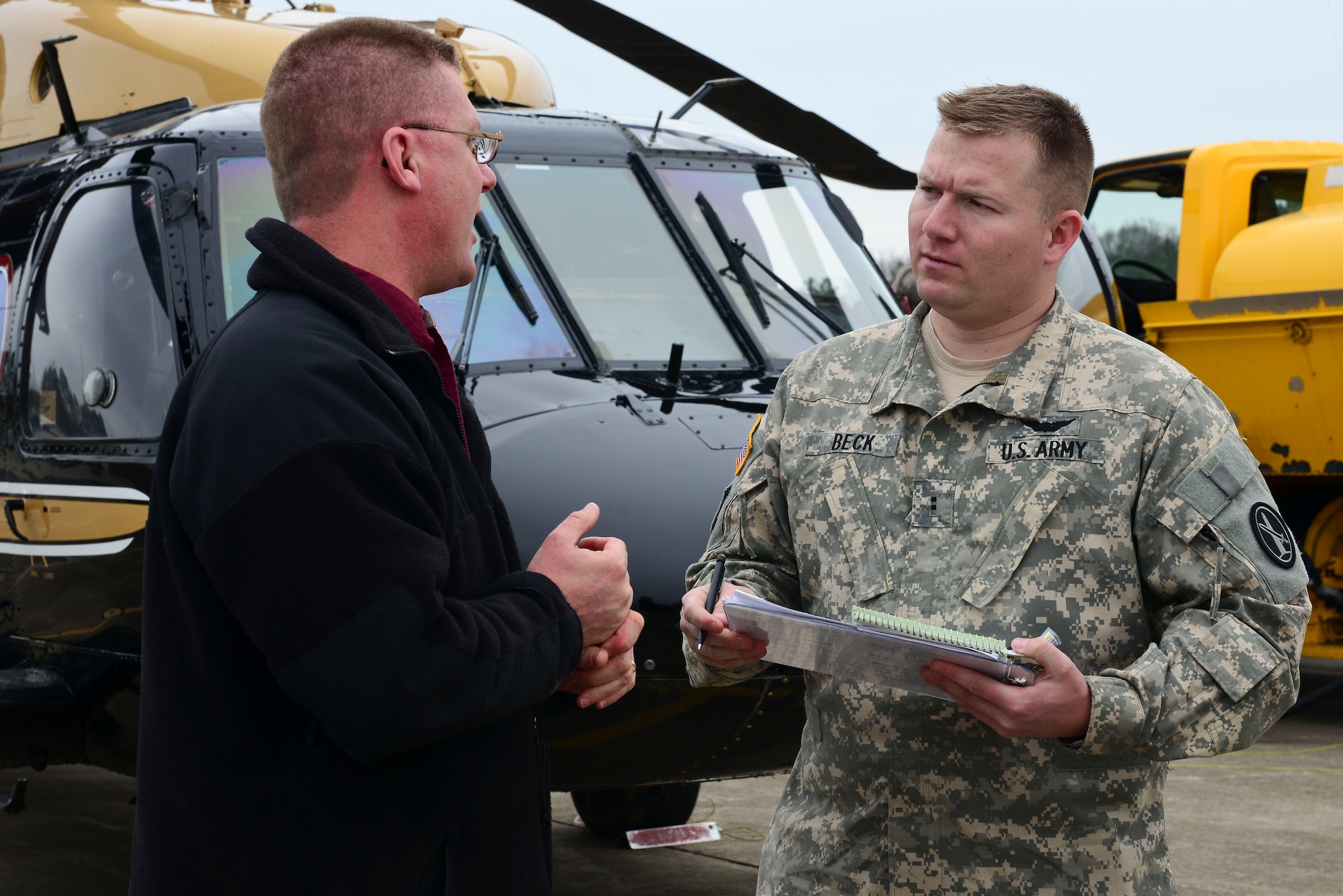 David Hanselman, U.S. Army Transportation Museum director, and U.S. Army Chief Warrant Officer 2 Michael Beck, Charlie Company, 12th Aviation Battalion pilot, discuss the VH-60 Blackhawk helicopter at Fort Eustis, Va., March 10, 2015. The 30-year-old retired aircraft to become the newest display for the museums aviation pavilion. (U.S. Air Force photo by Senior Airman Kimberly Nagle/Released)
