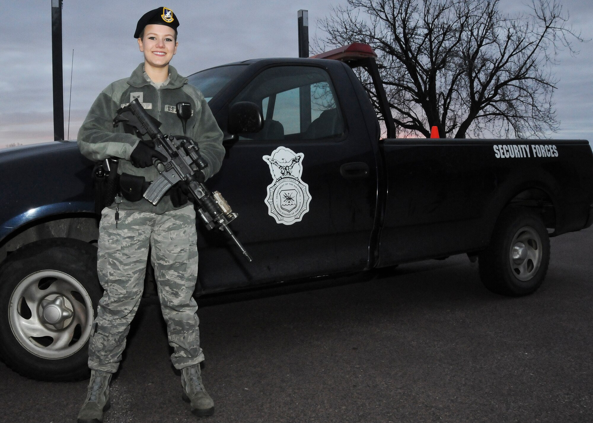 Senior Airman Jorrie Hart, 114th Security Forces Squadron installation controller, poses next to her patrol vehicle during an evening shift at Joe Foss Field, S.D., Feb. 24, 2015. While on patrol, Hart watches over 114th Fighter Wing assets and checks the entire base for any unsecure areas or discrepancies that may need to be reported to the base defense operations center.(National Guard photo by Staff Sgt. Luke Olson/Released)