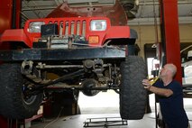 Retired U.S. Air Force Master Sgt. Reagan Ross, a local mechanic, puts a tire back on his vehicle in the Auto Hobby Shop March 10, 2015, at Moody Air Force Base, Ga. The shop provides the tools and equipment necessary for people who want to work on personal cars. (U.S. Air Force photo by Airman 1st Class Kathleen D. Bryant/Released)
