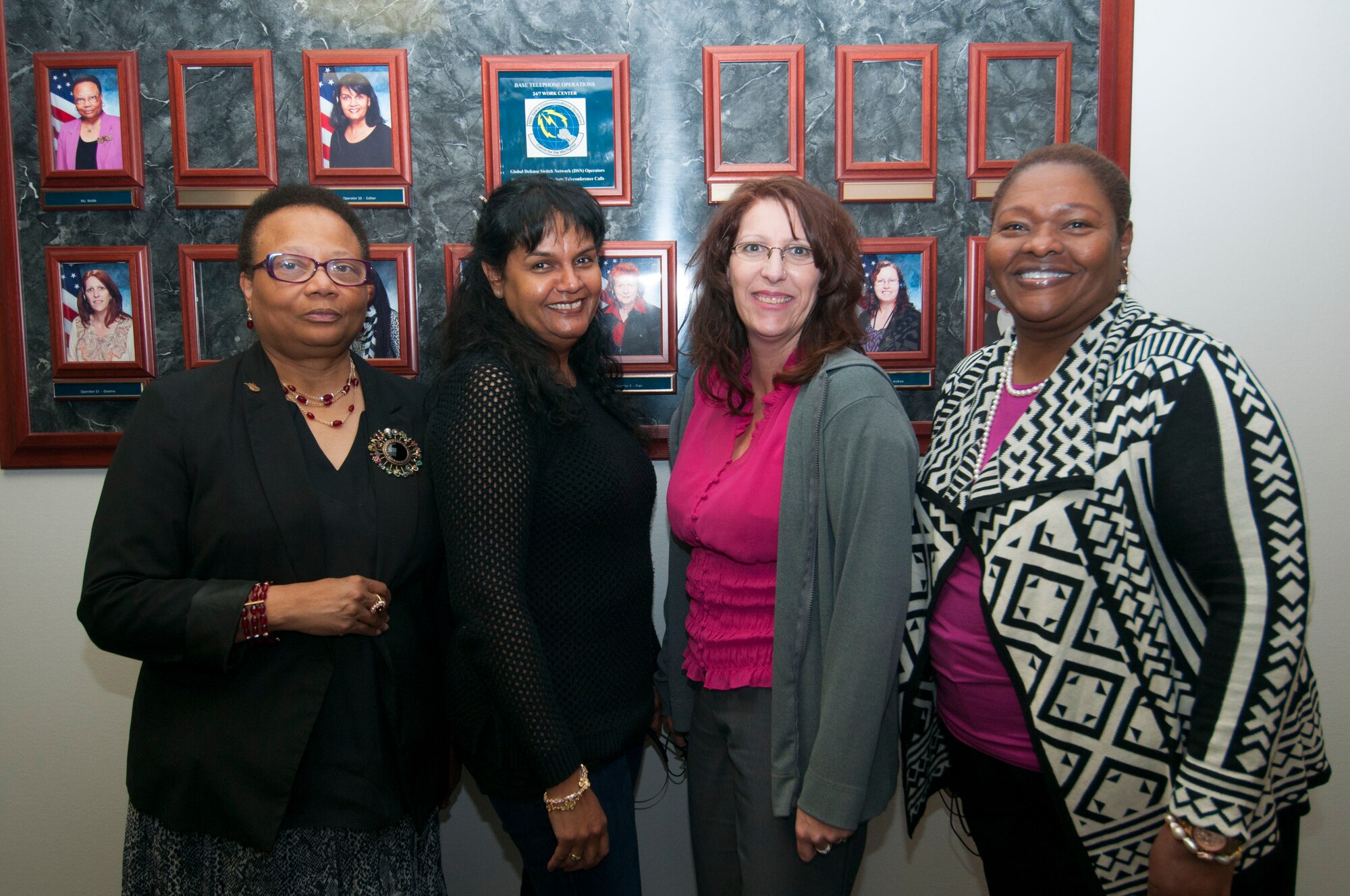 (From left) Janice Webb, Esther Gutierrez, Deanna Bocanegra, and Tangela Lewis, 50th Space Communications Squadron Defense Switched Network global operators stand in front of the call center March 10,2015, at Schriever Air Force Base, Colo. The base is closing the doors to the operator shop doors due to budget cuts March 31, 2015. (Air Force Photo/Senior Airman Naomi Griego)