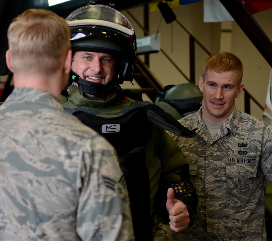 Senior Airman Aaron Haak, 39th Civil Engineer Squadron Explosive Ordinance Disposal technician, (left), and Senior Airman Kyle Lyon, 39th CES EOD technician, help a member of the NATO parliamentary assembly try on a bomb suit March 11, 2015, at Incirlik Air Base, Turkey.  Members of the NATO parliamentary assembly and their staff toured base and received hands-on demonstrations of military operations. (U.S. Air Force photo by Staff Sgt. Caleb Pierce/Released)