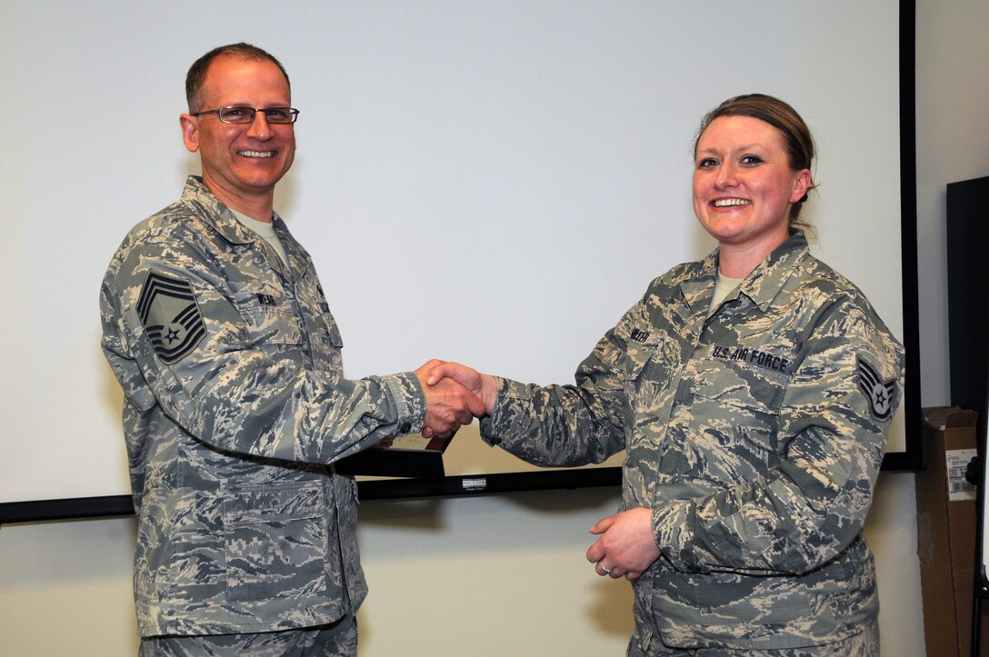 Chief Master Sgt. Brian Wear receives 2014 Chief of the Year Award from the 178th Wing Airman/NCO Council Vice President Staff Sgt. Desiree Miller at the Springfield Air National Guard Base, Ohio March 7, 2015.
The Airman/NCO Council presents the Chief of the Year Award annually.(Ohio Air National Guard photo by Airman Rachel Simones/Released)