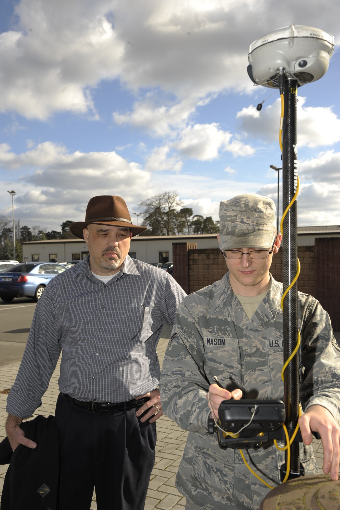 Eric Rushing, 86th Civil Engineer Squadron chief of engineering, watches as Airman 1st Class Justin Mason, 86th CES engineering technician uses a GPS rover to gain the coordinates of a water pipe at Ramstein Air Base, Germany, March 5, 2015. Rushing won the Harry P. Rietman Award (Senior Civilian Manager) for his work throughout 2014, which included the execution of more than 350 projects in the Kaiserslautern Military Community. (U.S. Air Force photo/Senior Airman Timothy Moore)