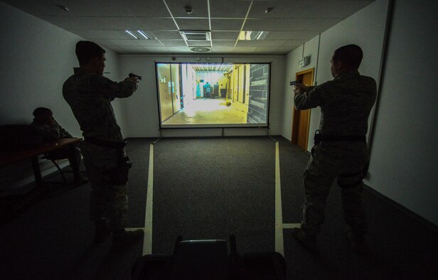 Airmen assigned to the 86th Security Forces Squadron react to a scenario during a firearms training system at Ramstein Air Base, Germany, March 6, 2015.  The training course helps give Airmen the confidence to react during real-world situations. (U.S. Air Force photo/Senior Airman Nicole Sikorski)