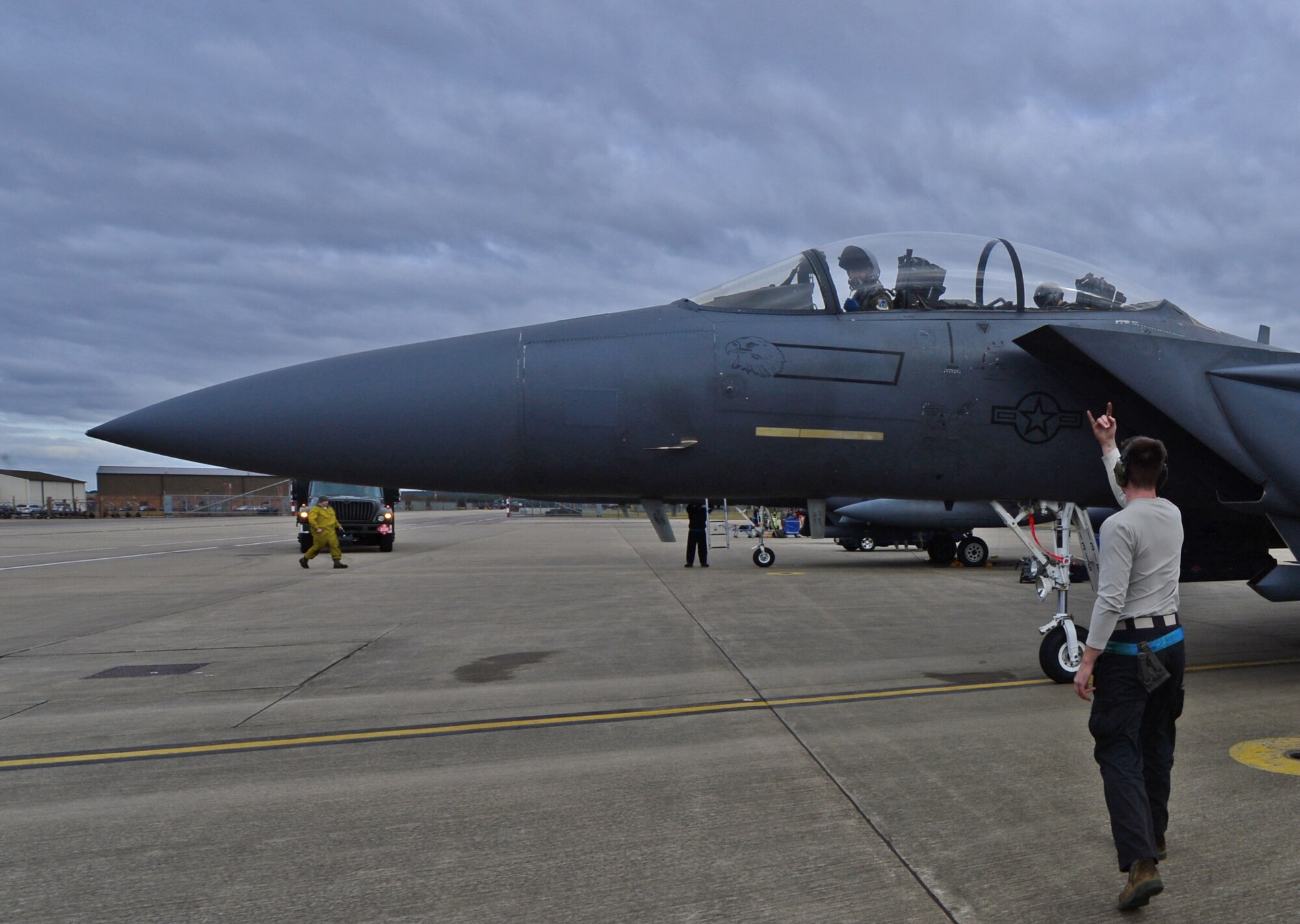 Airman 1st Class Tyler Burk, 492nd Aircraft Maintenance Unit assistant dedicated crew chief, signals an F-15E Strike Eagle pilot that he is clear to shut down the number two engine at Royal Air Force Lakenheath, England, March 5, 2015. The Liberty Wing’s aircrew had a record-breaking month of training flights, also known as sorties, for the month of February. (U.S. Air Force photo by Airman 1st Class Erin R. Babis/Released)