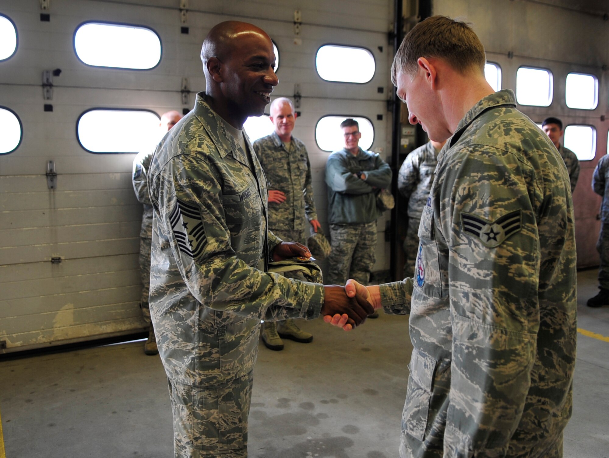 Chief Master Sgt. Kaleth Wright, 3rd Air Force command chief master sergeant, presents a coin to Senior Airman Kyle Ledford, 86th Civil Engineer Squadron firefighter, during his immersion tour on March 2, 2015, at Ramstein Air Base, Germany. Airmen demonstrated their capabilities and spoke to Wright about his experiences and Air Force current events. (U.S. Air Force photo/Airman 1st Class Larissa Greatwood)