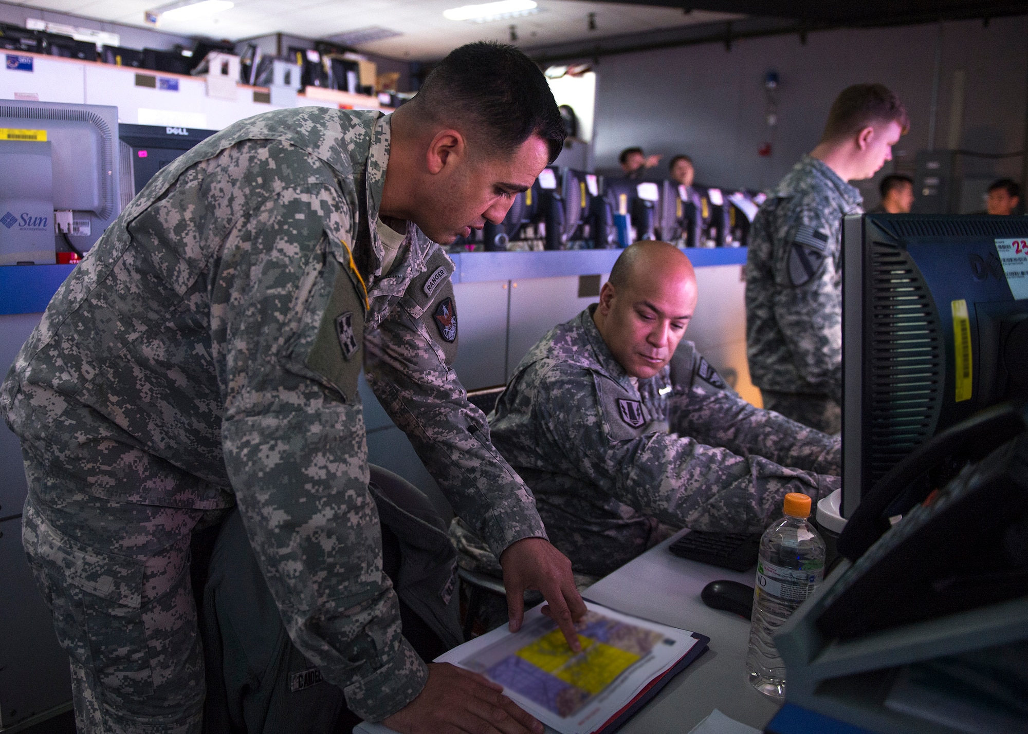 U.S. Army Capt. Otis Ingram explains predictions of space interference to a fellow Army officer March 10, 2015, in the Republic of Korea Air and Space Operation Center during exercise Key Resolve at Osan Air Base, Republic of Korea. Ingram is a space coordination officer from the 3rd Battlefield Coordination Detachment. (U.S. Air Force photo by Staff Sgt. Shawn Nickel/Released)
