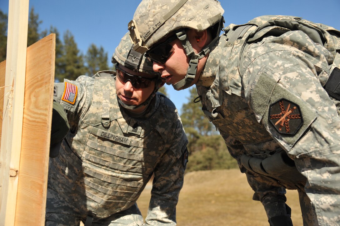 U.S. Army Sgt. Brian Everhart, right, and Command Sgt. Maj. Jeffrey Dillingham examine a paper target during the Installation Management Command-Europe Best Warrior Competition on Grafenwoehr Training Area in Germany, March 9, 2015. Everhart is assigned to U.S. Army Garrison Rheinland-Pfalz and Dillingham is assigned to U.S. Army Garrison Bavaria.