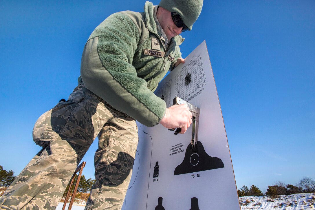 Air Force Senior Airman Joseph C. Paretti attaches a target in preparation for M4 carbine qualification on Joint Base McGuire-Dix-Lakehurst, N.J., March 8, 2015. Paretti is assigned to the New Jersey Air National Guard's 108th Wing.