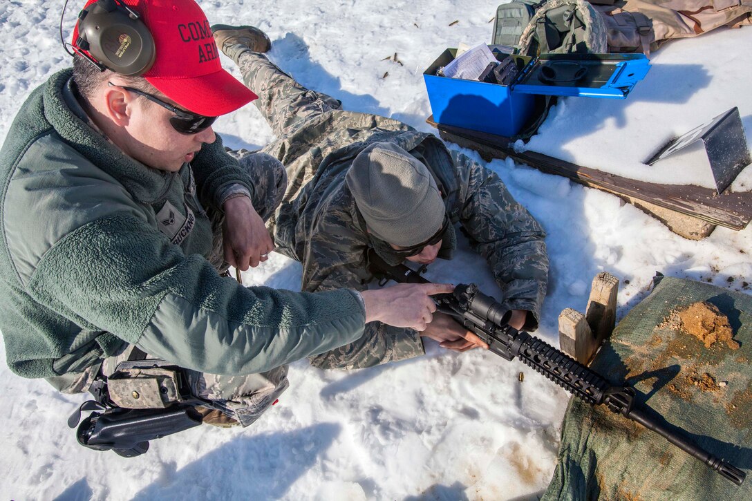 Air Force Senior Airman Raymond J. Buckno, left, helps Airman 1st Class Bryant A. Toro adjust the M68 red dot sight on his weapon during M4 carbine qualification on Joint Base McGuire-Dix-Lakehurst, N.J., March 8, 2015. Buckno and Toro are assigned to the New Jersey Air National Guard's 108th Wing.