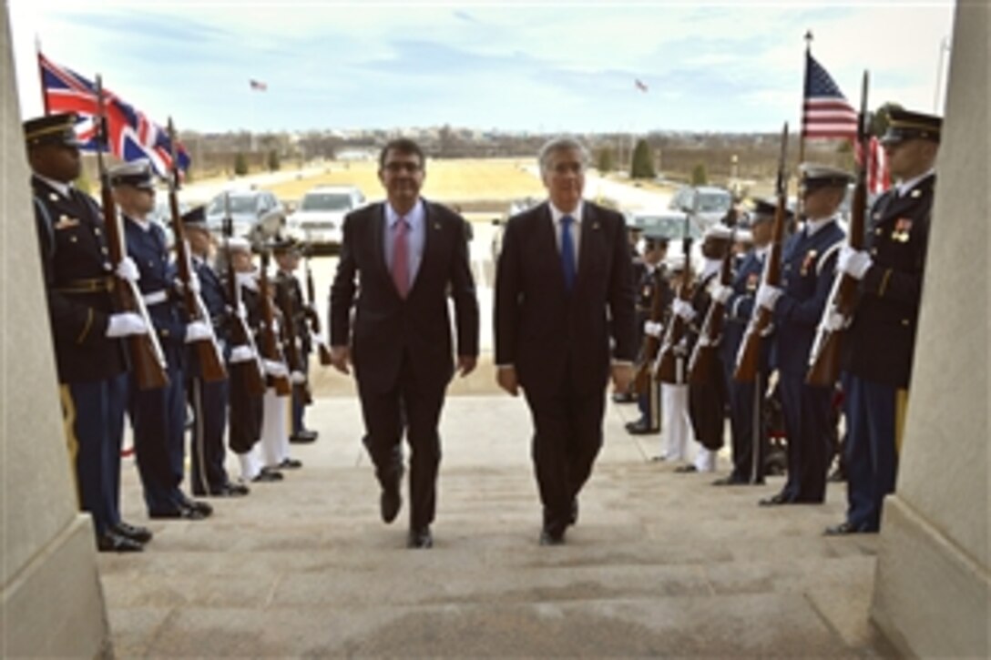 U.S. Defense Secretary Ash Carter, left, hosts an honor cordon to welcome British Defense Secretary Michael Fallon at the Pentagon, March 11, 2015. 
