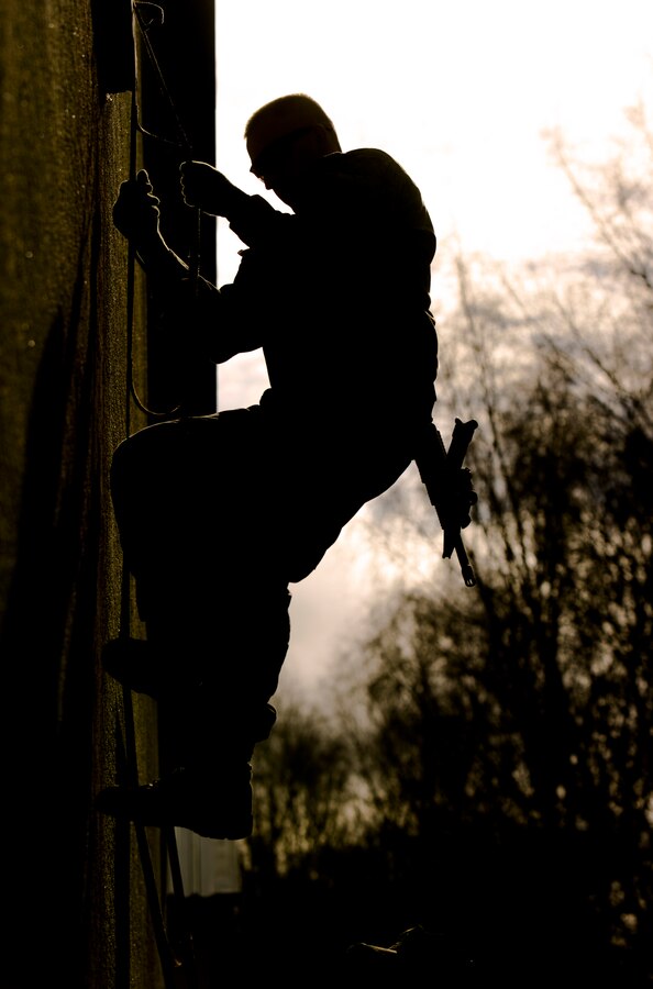 A U.S. Marine with Special-Purpose Marine Air-Ground Task Force Crisis Response-Africa climbs down a portable ladder during an urban obstacle course run by U.S. Army Special Forces in Baumholder, Germany, March 5, 2015. The lightweight ladder and hardened metal hooks allowed service members to scale a variety of obstructions to maneuver through or over buildings. (U.S. Marine Corps photo by Sgt. Paul Peterson/Released)
