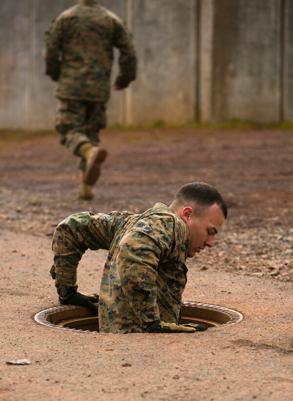 U.S. Marine 1st Lt. Matthew Medina, a platoon commander with Special-Purpose Marine Air-Ground Task Force Crisis Response-Africa, climbs out of a manhole during an urban obstacle course run by U.S. Army Special Forces in Baumholder, Germany, March 5, 2015. Special Forces personnel used their extensive knowledge of urban movement techniques to train the Marines to maneuver rapidly through the environment. (U.S. Marine Corps photo by Sgt. Paul Peterson/Released)