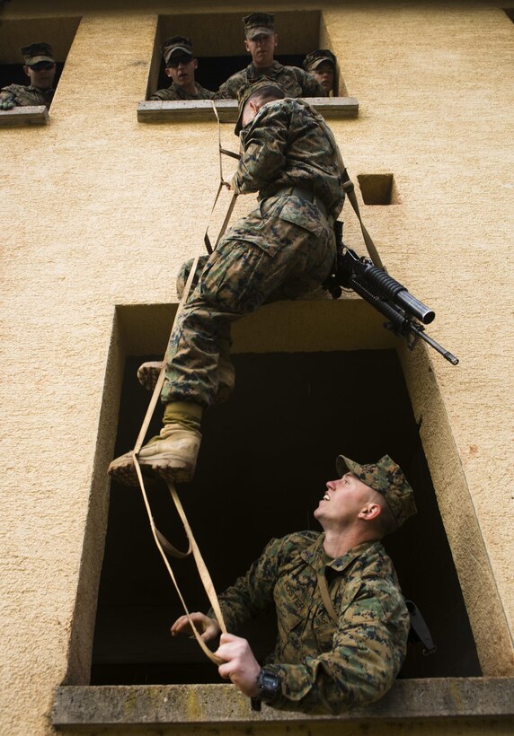 U.S. Marine Cpl. James Foster, bottom, with Special-Purpose Marine Air-Ground Task Force Crisis Response-Africa, stabilizes a portable ladder during an urban obstacle course run by U.S. Army Special Forces in Baumholder, Germany, March 5, 2015. The course prepared the Marines to use minimal equipment to conquer complex urban environments. (U.S. Marine Corps photo by Sgt. Paul Peterson/Released)