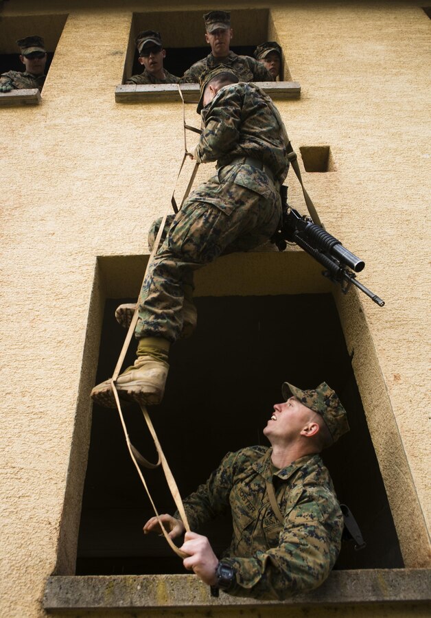 U.S. Marine Cpl. James Foster, bottom, with Special-Purpose Marine Air-Ground Task Force Crisis Response-Africa, stabilizes a portable ladder during an urban obstacle course run by U.S. Army Special Forces in Baumholder, Germany, March 5, 2015. The course prepared the Marines to use minimal equipment to conquer complex urban environments. (U.S. Marine Corps photo by Sgt. Paul Peterson/Released)