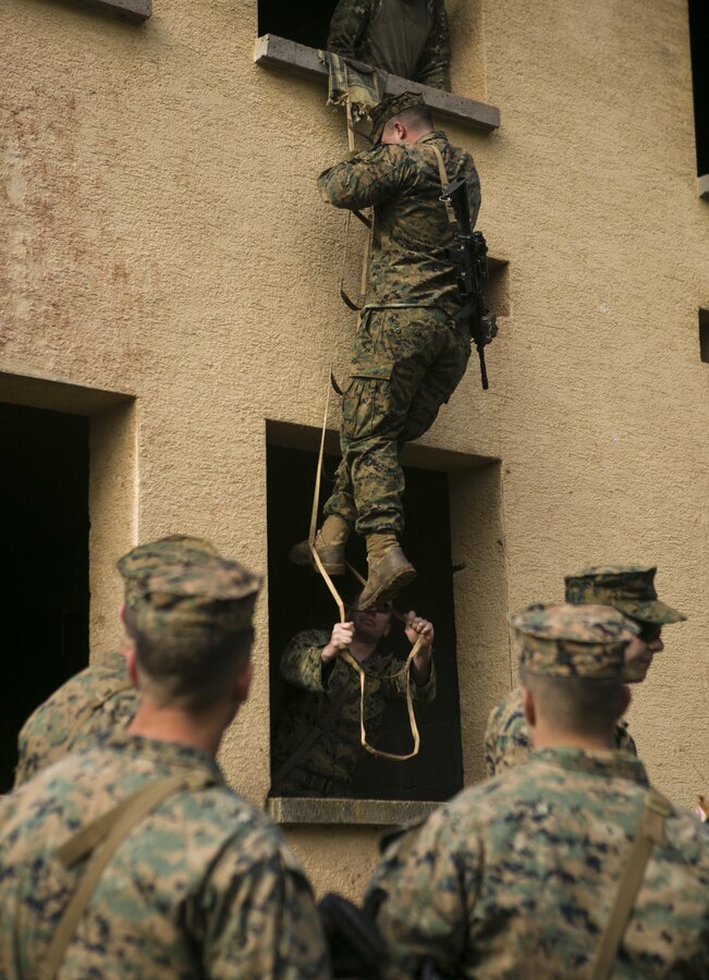 A U.S. Marine with Special-Purpose Marine Air-Ground Task Force Crisis Response-Africa climbs down a portable ladder during an urban obstacle course run by U.S. Army Special Forces in Baumholder, Germany, March 5, 2015. The lightweight ladder and hardened metal hooks allowed service members to scale a variety of obstructions and maneuver through buildings and over walls. (U.S. Marine Corps photo by Sgt. Paul Peterson/Released)