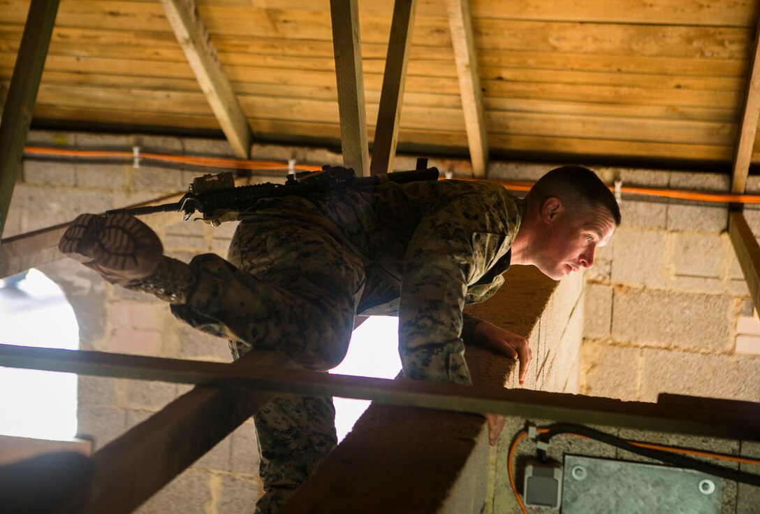 U.S. Marine Corps Sgt. Carl Clegg, a squad leader with Special-Purpose Marine Air-Ground Task Force Crisis Response-Africa, climbs into the rafters of a building during an urban obstacle course run by U.S. Army Special Forces in Baumholder, Germany, March 5, 2015. Clegg used the rafters to circumvent the buildings rooms as his team maneuvered to the other side of the structure. (U.S. Marine Corps photo by Sgt. Paul Peterson/Released)