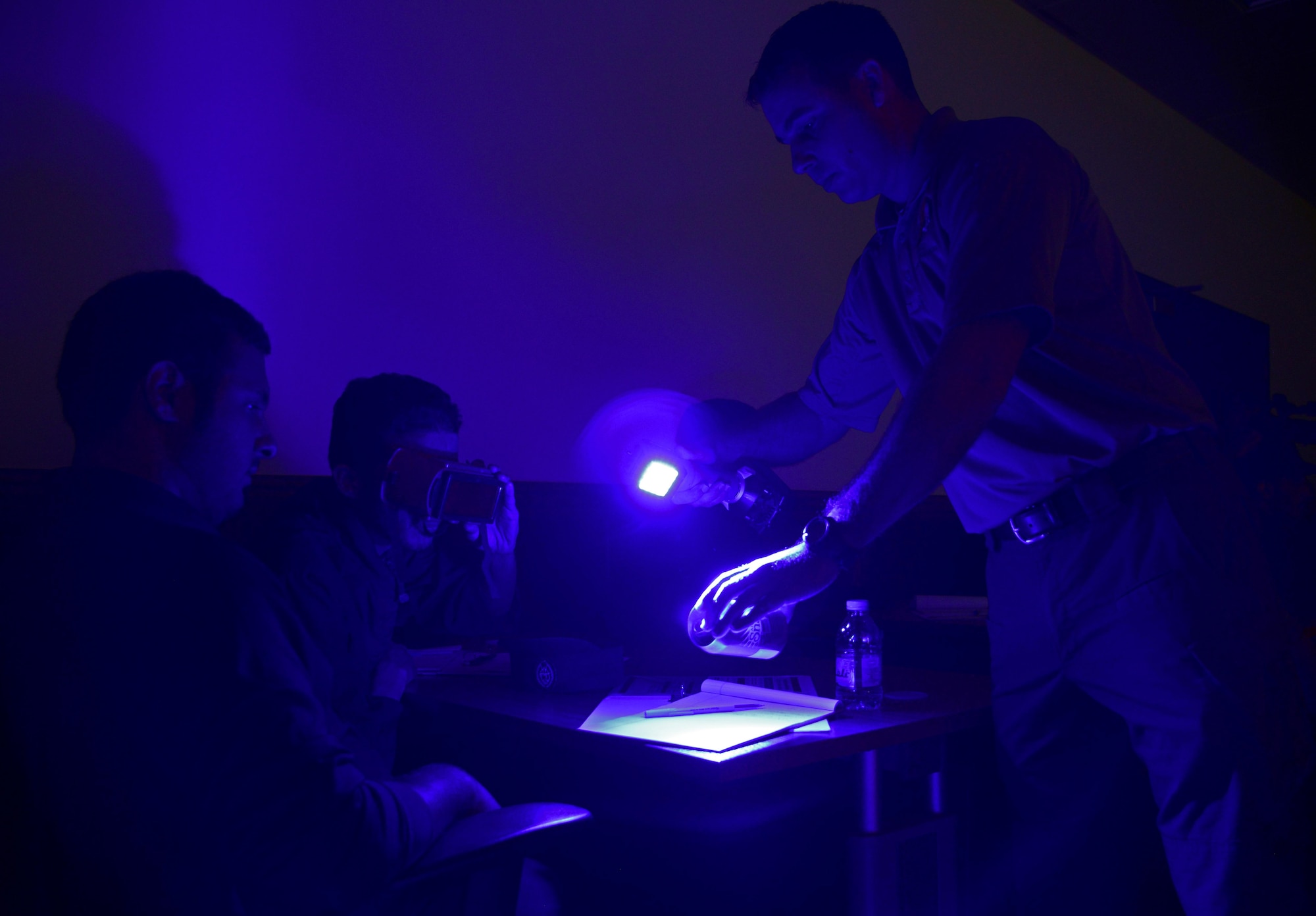 U.S. Special Agent Chad Hutchins, right, Forensics Science Consultant from the Federal Law Enforcement Training Center in Brunswick, Ga., shows a member of the Qatar Ministry of Interior’s Crime Scene Processing Unit a fingerprint on a can during a liaison exchange, March 3, 2015, at the Criminal Evidence and Information Department, Ar-Rayyan, Qatar. During the liaison exchange, members from Air Force Office of Special Investigations Detachment 241 and their Qatari counterparts shared different forensic methods they use when investigating a crime scene. Physical development of fingerprints using powders is just one of a selection of methods used to develop fingerprints. (U.S. Air Force photo by Senior Airman Kia Atkins)