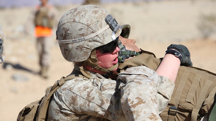 Cpl. Katie M. Gorz, team leader with 2nd Platoon, Company A, Ground Combat Element Integrated Task Force, conducts a fire-team assisted carry during a simulated casualty evacuation portion of a Marine Corps Operational Test and Evaluation Activity assessment at Range 107, Marine Corps Air Ground Combat Center Twentynine Palms, March 9, 2015. From October 2014 to July 2015, the GCEITF will conduct individual and collective level skills training in designated ground combat arms occupational specialties in order to facilitate the standards-based assessment of the physical performance of Marines in a simulated operating environment performing specific ground combat arms tasks.