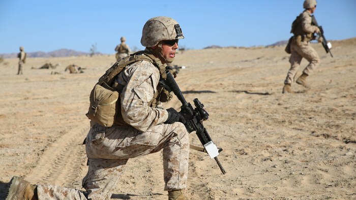Cpl. Kevin A. Miller, team leader with 2nd Platoon, Company A, Ground Combat Element Integrated Task Force, observes his fire team as they advance on their objective during a Marine Corps Operational Test and Evaluation Activity assessment at Range 107, Marine Corps Air Ground Combat Center Twentynine Palms, March 7, 2015. From October 2014 to July 2015, the GCEITF will conduct individual and collective level skills training in designated ground combat arms occupational specialties in order to facilitate the standards-based assessment of the physical performance of Marines in a simulated operating environment performing specific ground combat arms tasks. 