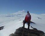 U.S. Air Force Chaplain Maj. Pete Drury stands atop Castle Rock, about an eight-mile hike from the town of McMurdo, with Mt. Erebus in the background. Chaplain Drury completed a deployment to Antarctica in support of Operation Deep Freeze, which in turn supports the United States Antarctic Program scientific research efforts.