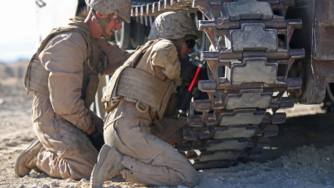 Sgt. Michael Meyer, left, crew chief, and Cpl. Kathryn Bynum, rear crewman, both with Amphibious Assault Vehicle Platoon, Company B, Ground Combat Element Integrated Task Force, work together to break track on an AAV during the assessment at Range 500, Marine Corps Air Ground Combat Center Twentynine Palms, California, March 5, 2015. From October 2014 to July 2015, the GCEITF will conduct individual and collective level skills training in designated ground combat arms occupational specialties in order to facilitate the standards-based assessment of the physical performance of Marines in a simulated operating environment performing specific ground combat arms tasks.