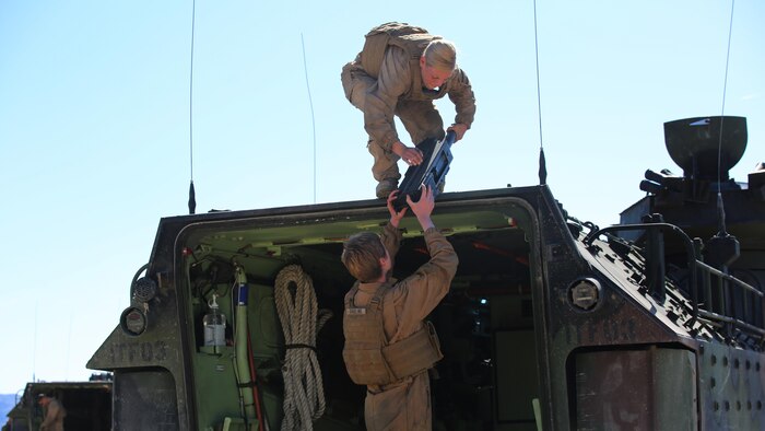 Sgt. Kassie McDole, top, crew chief, and Cpl. Kelsey Darling, rear crewman, both with Amphibious Assault Vehicle Platoon, Company B, Ground Combat Element Integrated Task Force, assist each other in weapons mounting during the assessment at Range 500, Marine Corps Air Ground Combat Center Twentynine Palms, California, March 5, 2015. From October 2014 to July 2015, the GCEITF will conduct individual and collective level skills training in designated ground combat arms occupational specialties in order to facilitate the standards-based assessment of the physical performance of Marines in a simulated operating environment performing specific ground combat arms tasks.