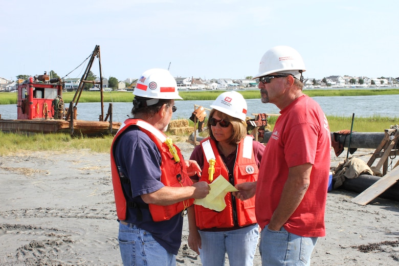 USACE Project Manager Monica Chasten (middle) discusses dredging and placement operations with USACE Inspector Charlie Yates (left) and Joe Hill (right), owner of Barnegat Bay Dredging Company. The U.S. Army Corps of Engineers has partnered with the state of New Jersey and several non-profit organizations on a dredging and marsh restoration project along the New Jersey Intracoastal Waterway. The demonstration project involves dredging critical shoals from the waterway and restoring ecological habitat.