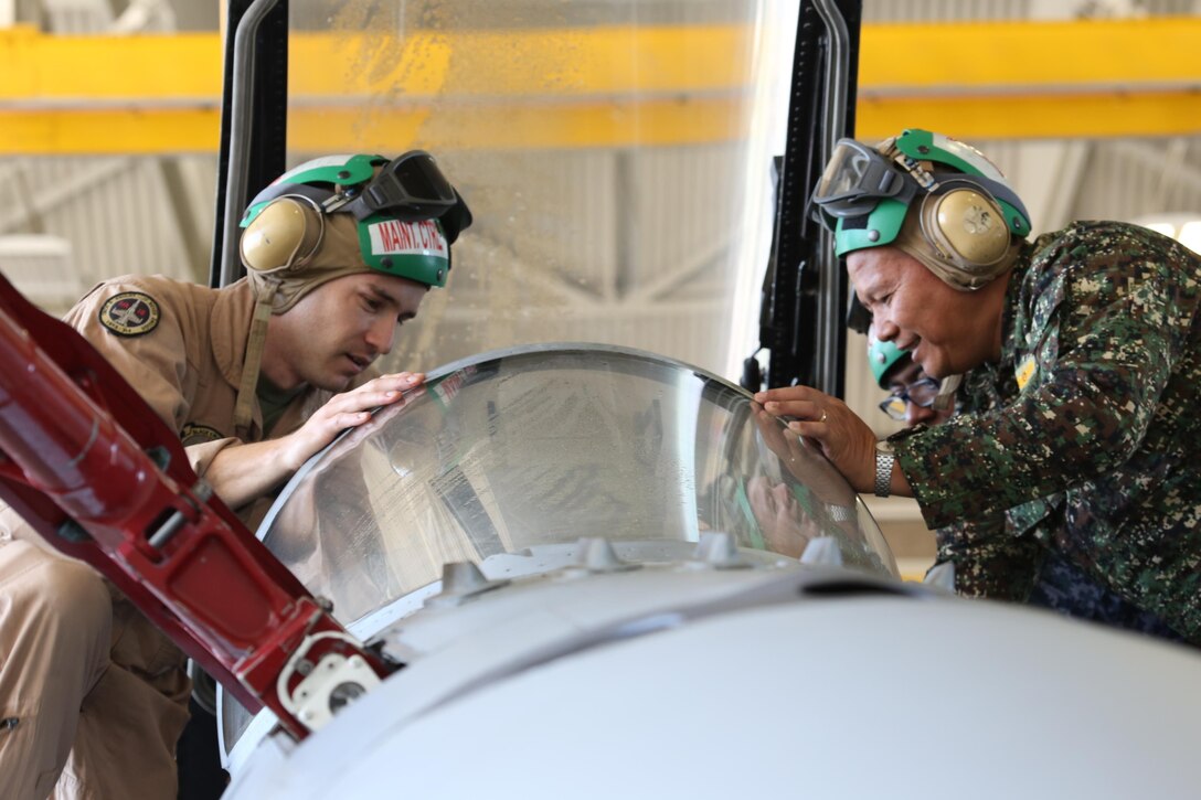 Capt. Scott Corbett, a flight officer with Marine Fighter Attack Squadron 314, shows Philippine Navy Cmdr. Hilarion Cesista the inside of an F/A-18 Hornet cockpit as part of a tour aboard Marine Corps Air Station Miramar, Calif. for the 58th annual International Senior Officer Amphibious Planning Course, March 10.