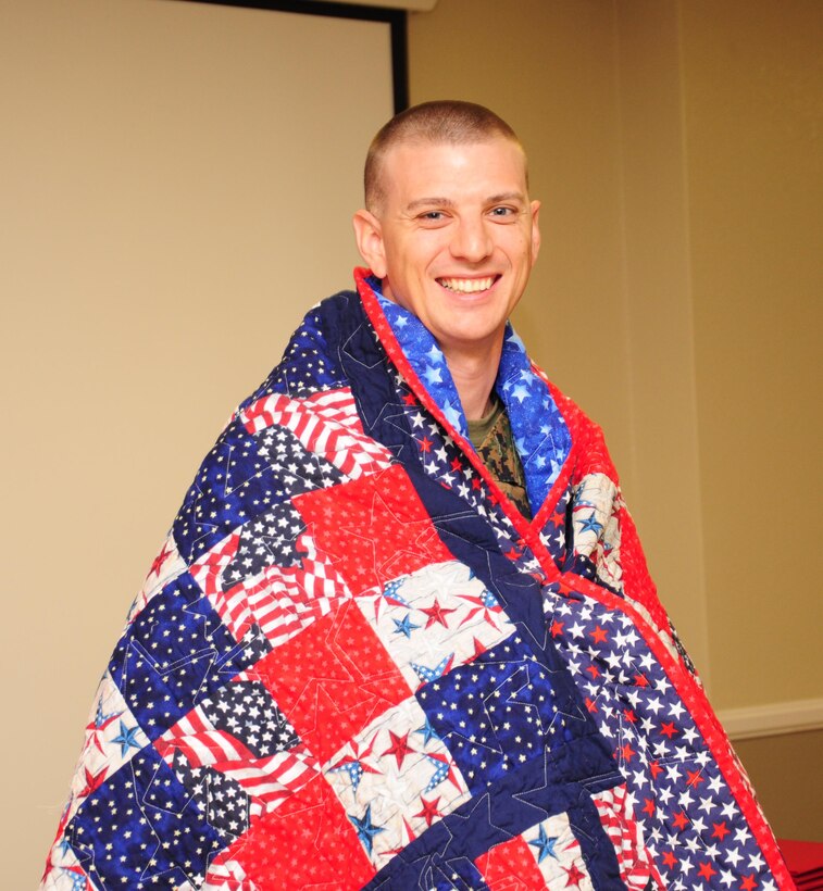 Capt. William A. Hemme, operations officer with Fleet Support Division,
during a Welcome Home Heroes presentation following his return from
Afghanistan and Kuwait. The patriotic-themed quilt was draped over
his shoulders by the Apple Valley Regional Chapter of Quilts of Valor.