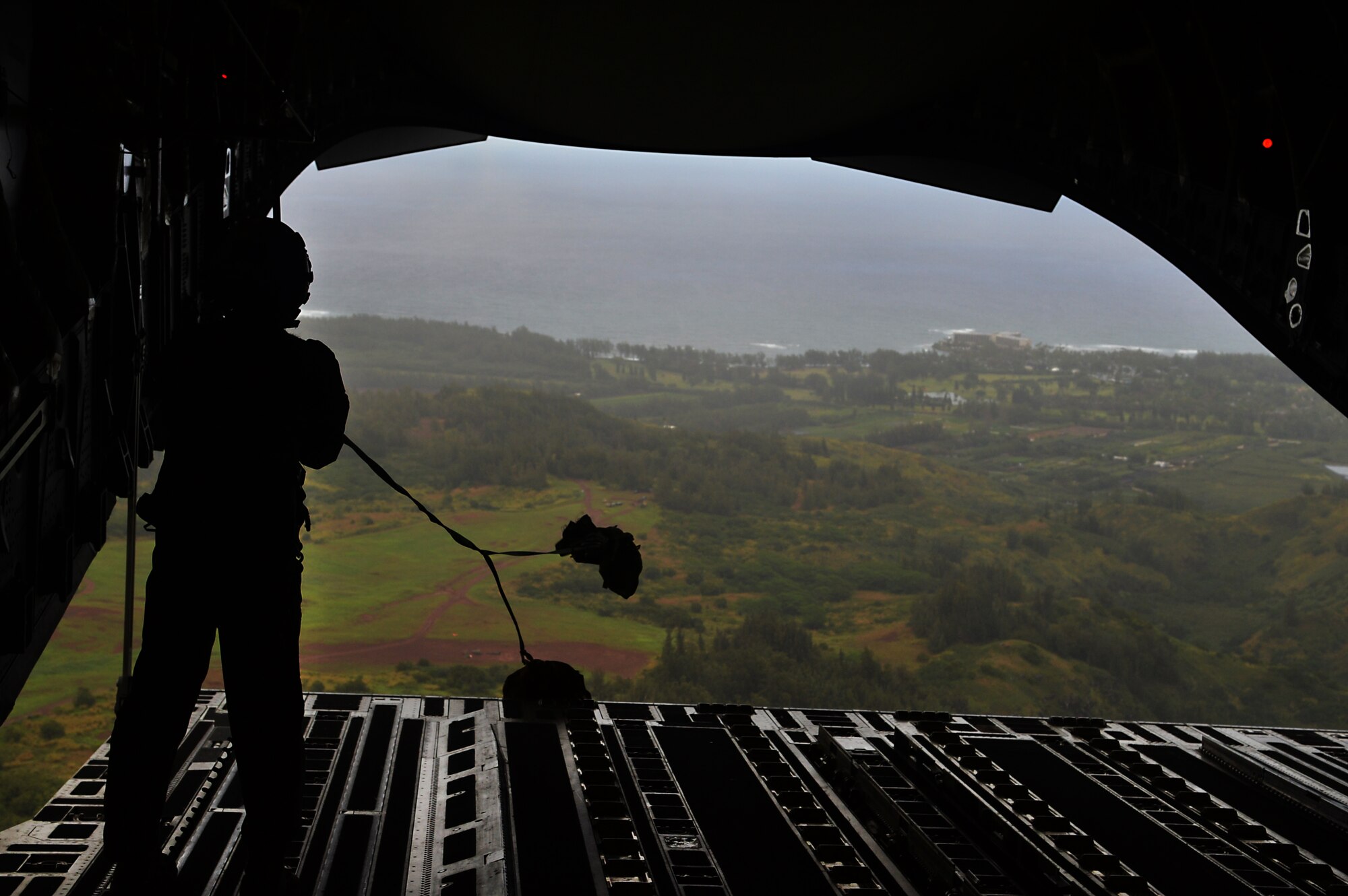 Staff Sgt. Alicia Muro, a loadmaster from the 535th Airlift Squadron, retrieves the parachute static lines after an airdrop of four combat delivery systems out the back of a C-17 Globelmaster III over Kahuku Training Area, Hawaii, Feb. 27, 2015. The airdrop supported the 25th Infantry Division’s Exercise Lightning Forge, a force-on-force scenario involving eight battalions. (U.S. Air Force photo by Tech. Sgt. Aaron Oelrich/Released)