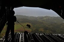 Staff Sgt. Alicia Muro, a loadmaster from the 535th Airlift Squadron, retrieves the parachute static lines after an airdrop of four combat delivery systems out the back of a C-17 Globelmaster III over Kahuku Training Area, Hawaii, Feb. 27, 2015. The airdrop supported the 25th Infantry Division’s Exercise Lightning Forge, a force-on-force scenario involving eight battalions. (U.S. Air Force photo by Tech. Sgt. Aaron Oelrich/Released)