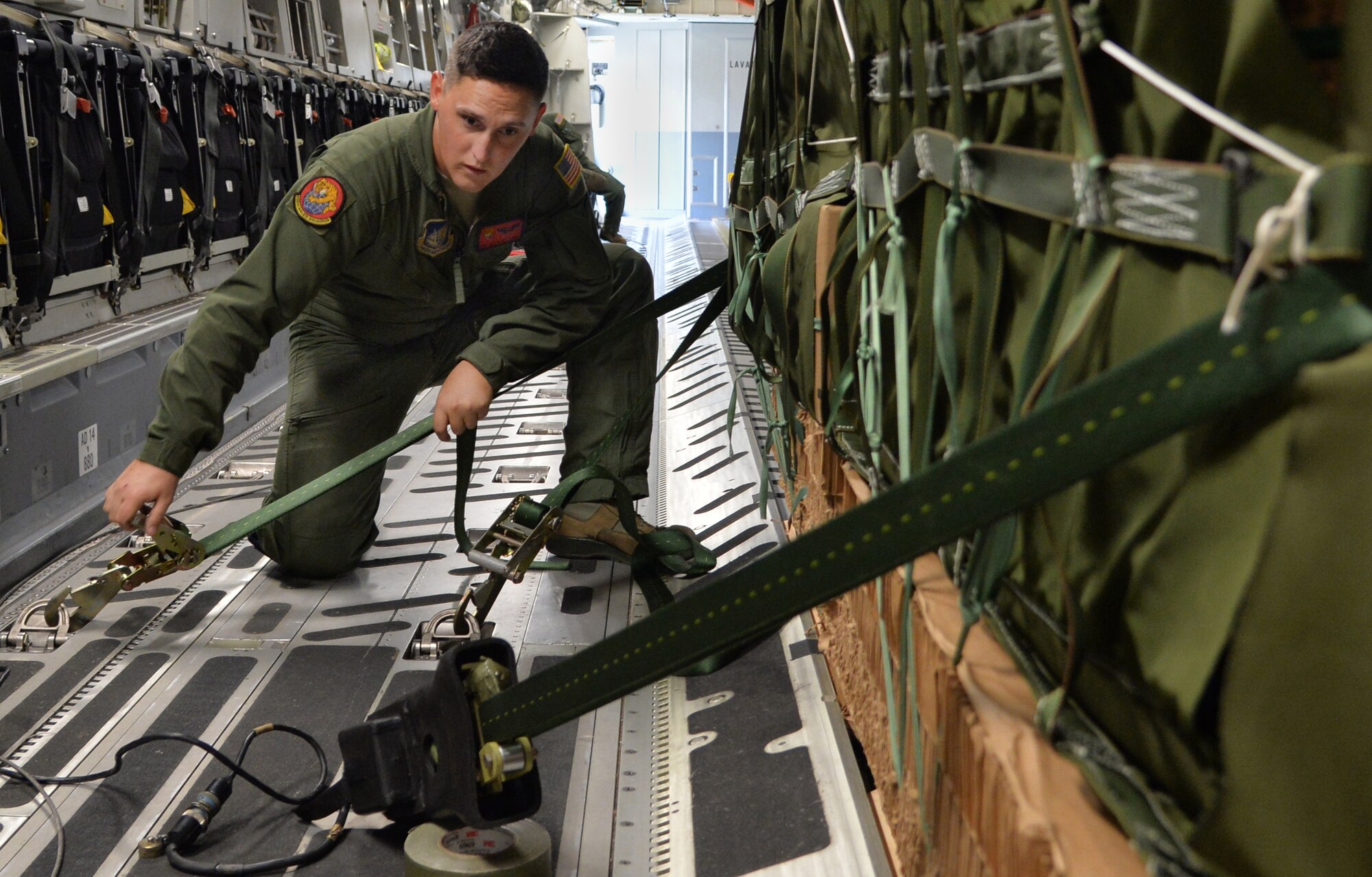 Senior Airmen Caleb Williams, a loadmaster from the 535th Airlift Squadron, secures four combat delivery systems in a C-17 Globelmaster III, in preparation for flight on Joint Base Pearl Harbor-Hickam, Hawaii, Feb. 27, 2015.The combat delivery systems will be airdropped to the 25th Infantry Division in support of Army Exercise Lightning Forge. (U.S. Air Force photo by Tech. Sgt. Aaron Oelrich/Released)