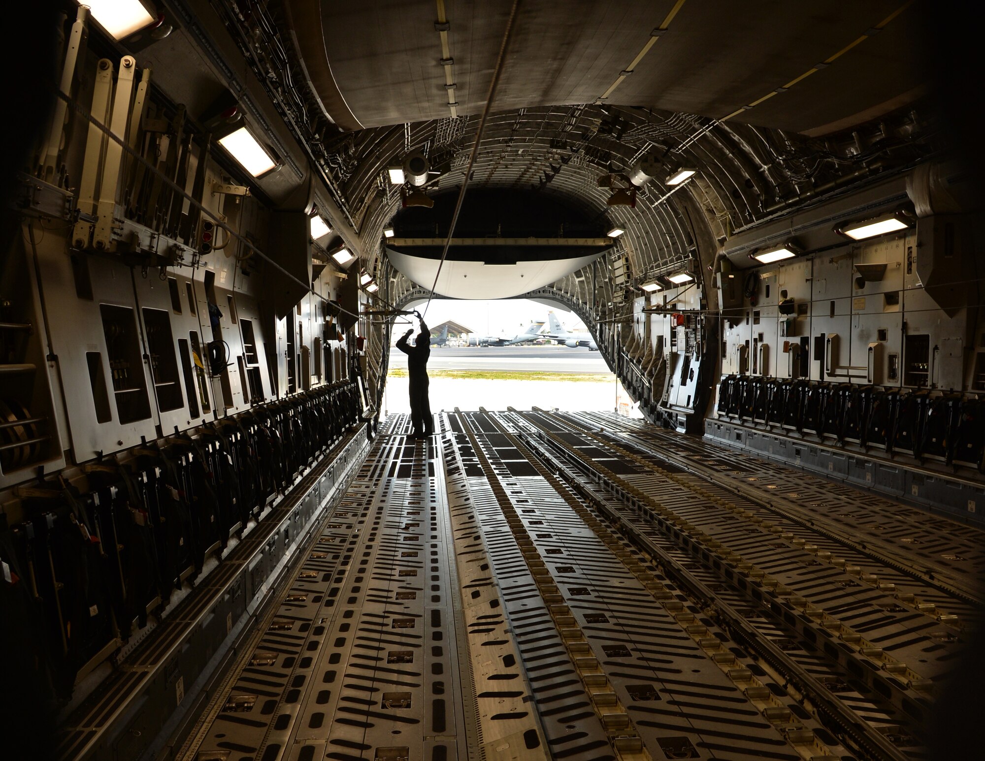 Senior Airmen Caleb Williams, a loadmaster from the 535th Airlift Squadron, checks the recovery cable on a C-17 Globelmaster III, Joint Base Pearl Harbor-Hickam, Hawaii, Feb. 27, 2015. The aircraft will drop four combat delivery systems in support of the 25th Infantry Division’s Exercise Lightning Forge. (U.S. Air Force photo by Tech. Sgt. Aaron Oelrich/Released)