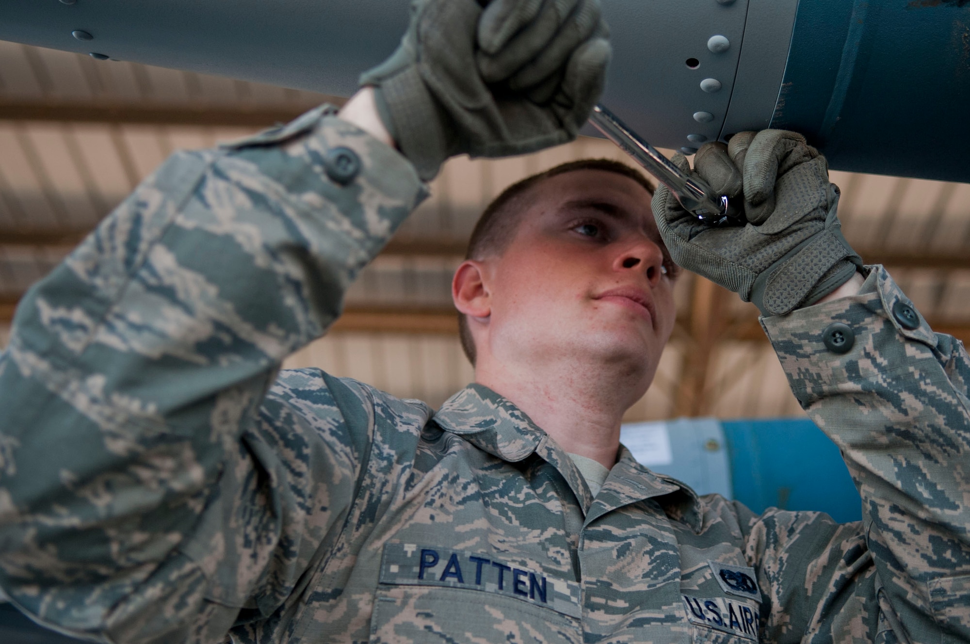 Senior Airman Forrest Patten, Offutt Air Force Base, Neb., 55th Maintenance Squadron stockpile surveillance member, tightens set screws on a tail fin at the munitions storage area on Nellis Air Force Base, Nev., March 10, 2015. Tightening the screws helps ensure that the tail fin doesn’t come off during transport or in flight. (U.S. Air Force photo by Airman 1st Class Mikaley Towle)