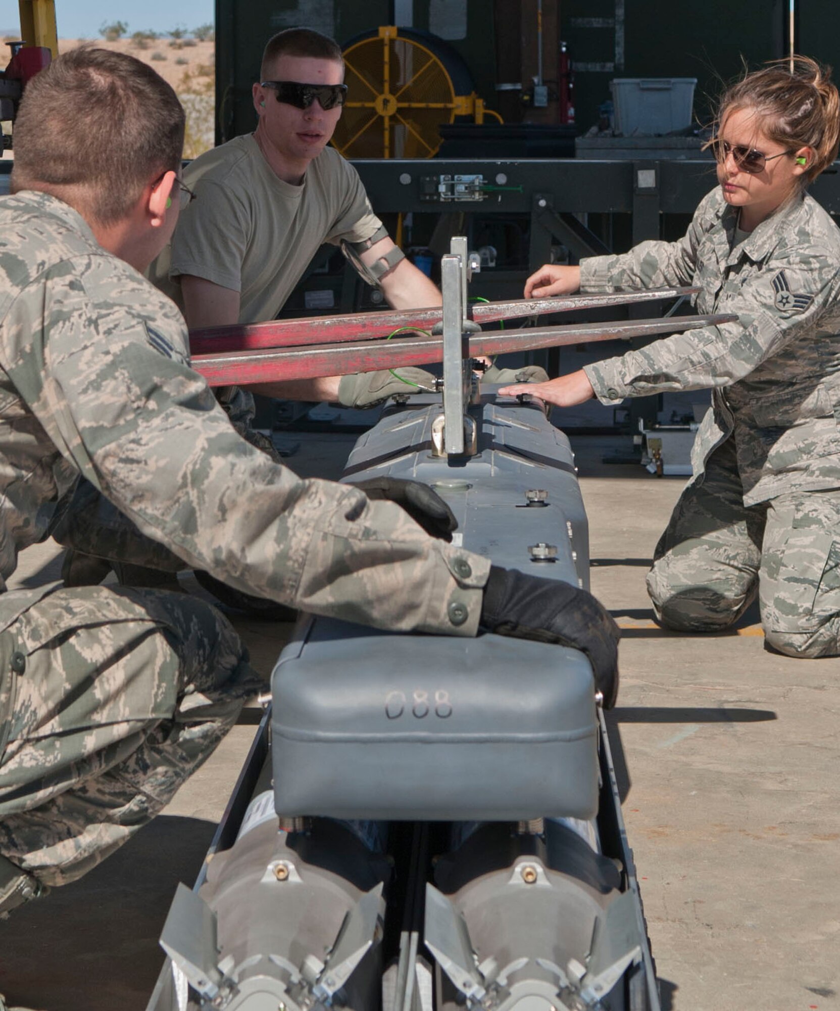 Airmen prepare a BRU-61 bomb rack at the munitions storage area on Nellis Air Force Base, Nev., March 5, 2015. Completed rounds are loaded onto trailers, or mods, and delivered to the flightline for line delivery. (U.S. Air Force photo by Airman 1st Class Mikaley Towle)
